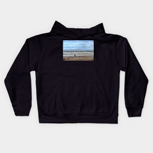 Walking the dog in blustery weather at Ardrossan, North Ayrshire, Scotland Kids Hoodie